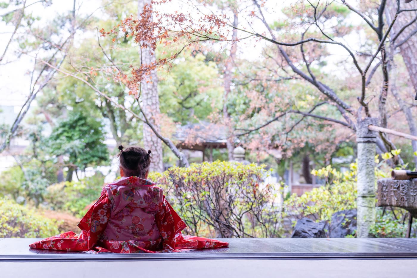 日本庭園の縁側に座る七五三の女の子の後ろ姿